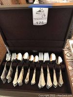 Full view of Cellar stainless steel flatware set arranged in a wooden box with multiple types of forks, spoons, and utensils.