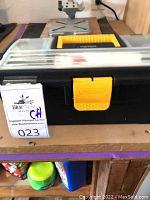 Clear photo of the black and yellow plastic toolbox with transparent lid closed, showing general condition and external appearance