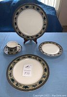 Set of dinnerware displayed on table with a platter, dinner plates, salad plates, and a mug to show design and size.