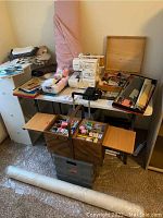 Overview of serger on table with wooden sewing box, plastic tub and fabric rolls