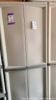 Front view of beige Sterilite storage cabinet with two top and two bottom doors closed.