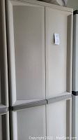 Front view of white Sterilite double door storage cabinet, showing overall cabinet design.