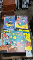 Five vintage Disney comic books with colorful illustrated covers featuring Donald Duck, Daffy Duck, and Uncle Scrooge arranged overlapping.