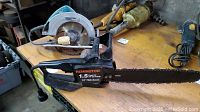 Makita circular saw and Remington electric chain saw side by side on a table