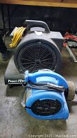 Two power dryers together: black Powr-Flite PD-500 with yellow cord and blue B-Air VP-20 fan.