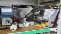 Black & Decker Powerfile tool with original box, oxygen pressure gauge with valve and pressure dial, analog voltmeter visible in background.