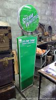 Photo showing the full height and shape of the green Steam Whistle Pilsner sign including circular logo and rectangular body.