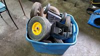 Bin filled with various wheels of different sizes and conditions, including rubber tires with metal hubs and caster wheels.