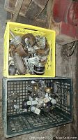 Photo showing two plastic crates containing various caster wheels and mixed wheels of different sizes and types.