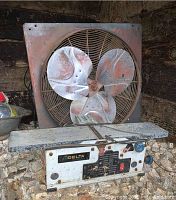 Delta planer showing evidence of heavy use and rust, large rusted industrial fan behind it