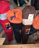 Five camping chairs in various colored carry bags arranged together