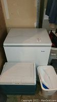 Haier chest freezer shown closed with two coolers in front, one large plastic cooler and one smaller foam cooler.