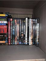 Shelf with various DVDs including war and historical titles
