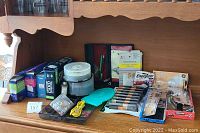 Office supplies laid out including boxes of envelopes, DVD-R, CD-R discs, batteries, and small office accessories