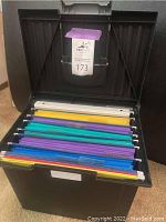 Open black plastic filing cabinet showing colorful hanging folders organized inside.