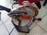 Side view of 10 inch Tradesman compound miter saw showing blade, handle, and base