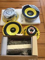 Photo showing 2 pairs of yellow Pyle speakers and subwoofers along with boxed head unit wrapped in protective foam and plastic.