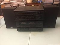 Full view of stereo system with speakers on each side, showing stacked components and speaker cabinets.