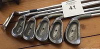 Photo showing six Ping Zing irons numbered 1 through 5 plus pitching wedge with steel shafts, used condition