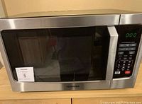 Front view of Toshiba stainless steel microwave oven with digital display and keypad.