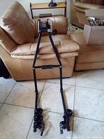 The trailer hitch bicycle carrier rack showing its full frame and bike mounting arms with clamps and straps for securing bikes.