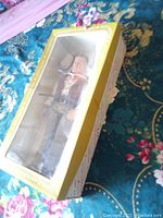Photo of the John Wayne doll in original box with clear display window showing doll in Western outfit and rifle.