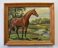 Full view of the framed painting depicting a brown horse standing in a natural landscape with trees and water.