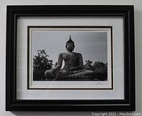 Framed photo of a seated Buddha statue in black and white showing full image.
