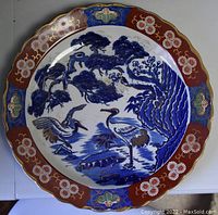 Full view of decorative plate showing crane design and ornate border.