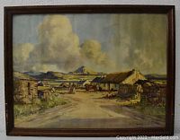 Full view of the framed landscape print showing the village, road, mountains, and dramatic clouds.