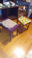 Full shot of the vintage wooden stool with purple needlepoint top and vintage wooden chair with floral upholstered seat on wood floor