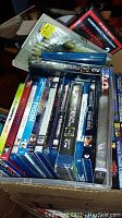 Photo showing Blu-Ray DVD titles Frozen, Transformers 3, Doctor Strange and others stacked in a box.