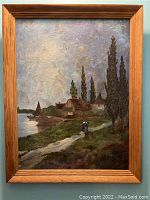 Front view of framed oil painting depicting lakeside village landscape with path, figures, trees and sailboat