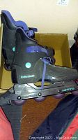 Side view of men's black and purple rollerblades with visible brand name and wheel setup.