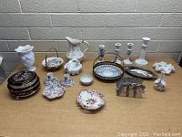 Wide shot showing entire box lot of assorted vintage and decorative ceramic items arranged on table.