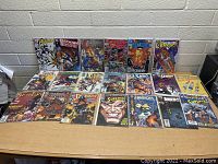 Comic books arranged in two rows on a table, showing various titles including Batman, Superman, and Fantastic Four.