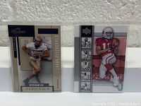 Two Larry Fitzgerald rookie football cards displayed side by side against a textured wall background.