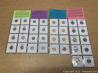 Wide shot of four rows of assorted coins in cardboard holders, each row topped with color-coded informational cards describing the coin series.