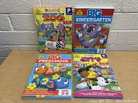 Four pre-school and kindergarten learning books arranged on a table against a neutral wall. The titles are visible with colorful animal and character illustrations on covers.