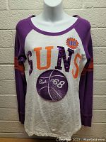 Front view of long sleeve women's shirt in Phoenix Suns purple and white with embellished logo and text