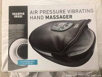 Box front shows the hand massager glove with control buttons and Sharper Image branding.