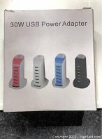 Box front showing four color options of the 30W USB Power Adapter charging hubs: red, white, blue, and black.