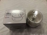 Photo of the food chopper unit beside its original box showing the product name and image.