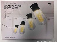 Front packaging showing close-up of 4 Edison style LED bulbs attached on black cord with branding and product features such as weather-resistant and dual light modes.