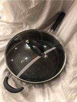 Sauté pan with attached glass lid showing the top view including lid handle and vent hole.