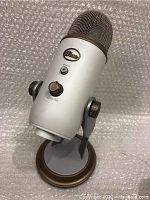 Blue Professional Series USB Microphone showing mute button, volume knob, and Blue logo on front with bronze grill and base on bubble wrap background.