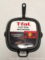 Front view of the T-fal cast iron square grill pan with label showing brand, durability, and compatibility with all stovetops and induction.