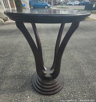 Front view showing the pedestal base and curved supports of one side table.