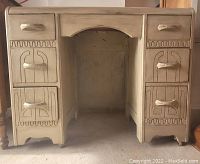 Front view of a primitive style antique desk showing front drawers and carved geometric patterns on the drawer fronts and panels.