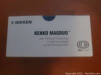 White and blue rectangular box with 'Nikken Kenko MagDuo' branding and TriPhase Technology logo on the top showing product packaging.